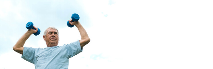 Senior man working out outdoor. Person lifting dumbbells. Old male exercising against blue sky. Healthy people lifestyle. Active sport training. Older elderly sportsman doing fitness exercise. Workout