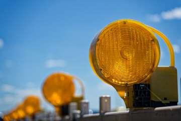 Yellow construction site Road work warning lamps on plastic barriers for road closures