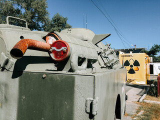 Military vehicle with Chernobyl warning sign in the background during daytime