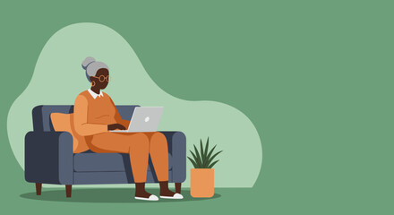 Elderly African American woman comfortably uses a laptop on a sofa at home, showcasing modern senior lifestyle, online learning, or remote work.