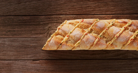  Baguette mit Knoblauchbutter angeschnitten auf rustikalem Holzfond, Kräuterbrot, Kräuterbutter, 