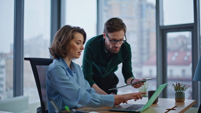 Friendly coworkers collaborating business report in modern office closeup.