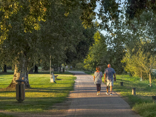 Two senior adults in casual clothing walking at sunset