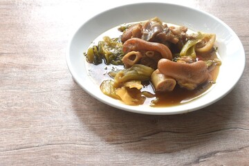 boiled braised salty pork leg and slice pickled cabbage in Chinese herb brown soup on plate