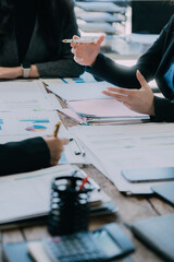 Teams work on project strategy, prepare reports, point to infographics on the conference table....