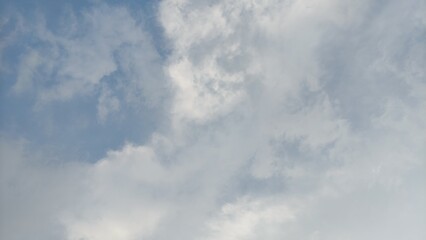 Slow moving white cumulus clouds. Blue sky with several layers of clouds.timelapse capturing soft, white clouds drifting peacefully against a bright blue sky. Perfect for stock footage, cinematic back