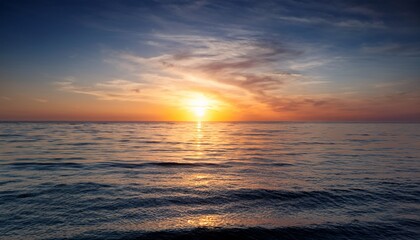 Obraz premium serene sunset over calm ocean waves with golden sand and colorful clouds