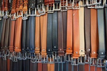 Close-up of men's leather belts made in Italy, for sale at a street market