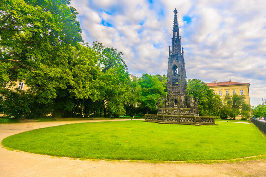 Vibrant park in the center of Prague with green lawns, blooming flowers, walking paths and a backdrop of historic architecture and famous landmarks of the Czech capital city