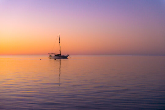 Tranquil yacht anchored at sea during a colourful sunset