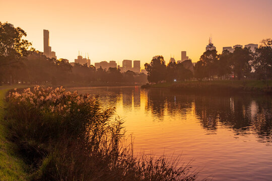 Low angled view of  golden foggy sunlight reflected on an inner city river at sunset