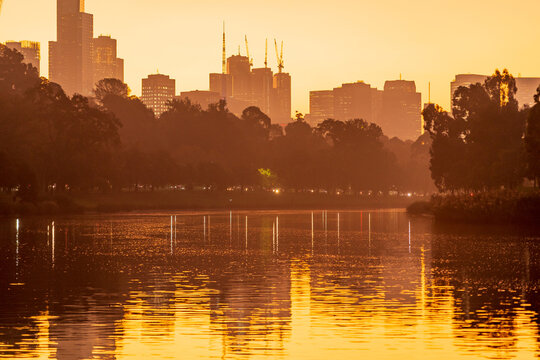 Low angled view of  golden foggy sunlight reflected on an inner city river at sunset
