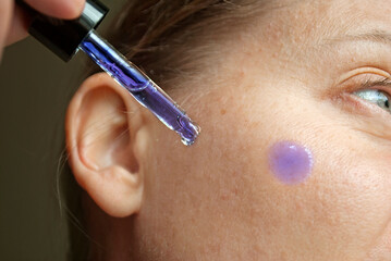 Woman applying Methylene Blue Serum to her face