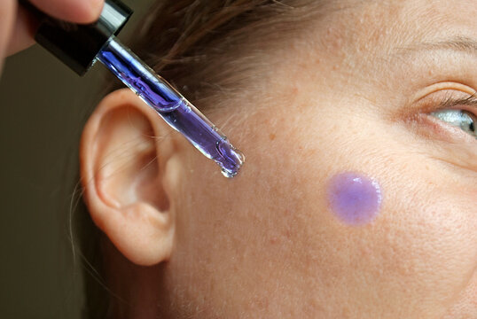 Woman applying Methylene Blue Serum to her face