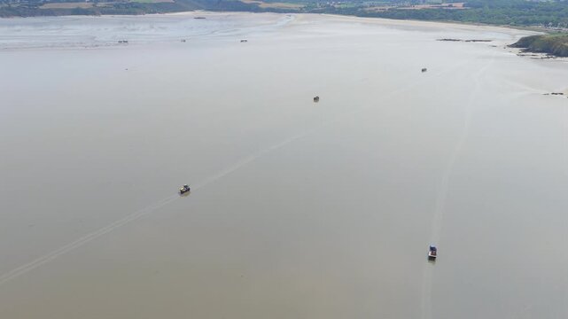 Aerial view of farmers harvesting mussels and oysters at low tide