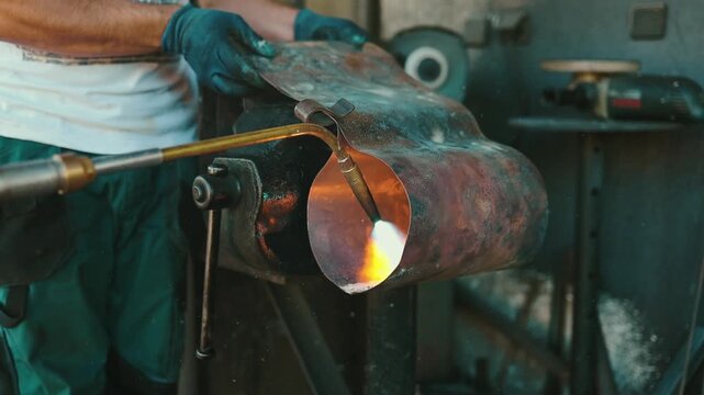 Traditional coppersmith workshop for copper brewing pots manufacturing. This handmade brewery kettles will be used for making traditional alcohol brandy drinks. Small traditional business concept.