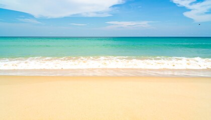 Tranquil Beach Scene: Turquoise Ocean Waves Crashing on Golden Sand Under Blue Sky