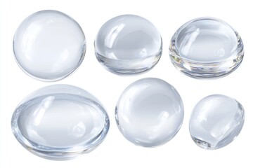 Transparent glass orbs of varying sizes, some flattened, scattered on a white surface