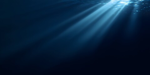 Obraz premium A dark blue background with rays of light shining down, creating an underwater effect. 