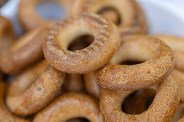 Freshly baked mini bagels on a dark background. Top view. Pretzels in the form of a ring close-up. Small bread circle biscuit. Bowls with different types of bagels.