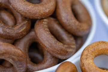Freshly baked mini bagels on a dark background. Top view. Pretzels in the form of a ring close-up. Small bread circle biscuit. Bowls with different types of bagels.