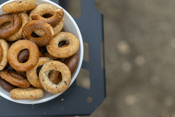 Freshly baked mini bagels on a dark background. Top view. Pretzels in the form of a ring close-up. Small bread circle biscuit. Bowls with different types of bagels.