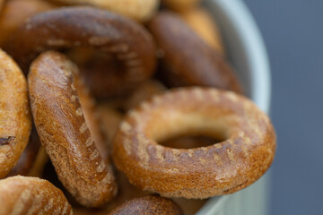 Freshly baked mini bagels on a dark background. Top view. Pretzels in the form of a ring close-up. Small bread circle biscuit. Bowls with different types of bagels.