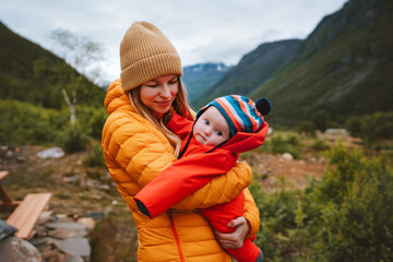 Mother with baby family walking in mountains travel outdoor mother and child together, woman with...