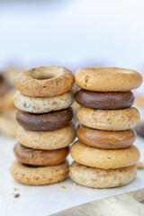 Freshly baked mini bagels on a dark background. Top view. Pretzels in the form of a ring close-up. Small bread circle biscuit. Bowls with different types of bagels.