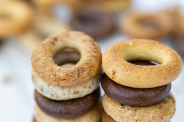 Freshly baked mini bagels on a dark background. Top view. Pretzels in the form of a ring close-up. Small bread circle biscuit. Bowls with different types of bagels.