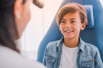 Cheerful boy at otolaryngologist for diagnostic in medical center. Larynx laryngitis illnesses...