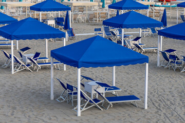 Empty Beach with Closed Umbrellas and Sun Loungers, tourist resort, Tyrrhenian Sea, Viareggio, Italy.