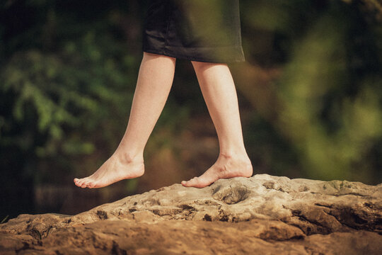 une femme baladant pieds nus sur un rocher