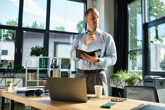 Inspirational young businessman reflects on ideas in modern office space filled with greenery