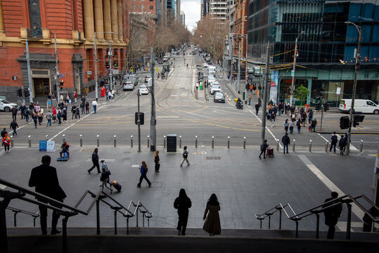 Bourke Street in Melbourne with pedestrians passing in silhouette
