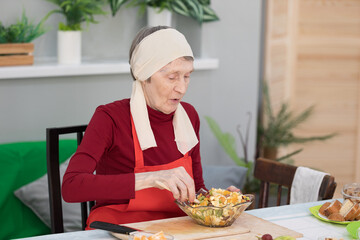 Elderly woman preparing fruit salad at home in the living room