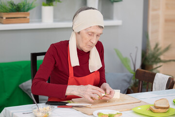 Elderly woman preparing fruit salad at home in the living room