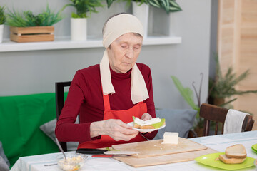 Elderly woman preparing fruit salad at home in the living room