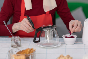 Elderly woman preparing fruit salad at home in the living room