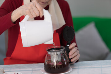 Elderly woman preparing fruit salad at home in the living room