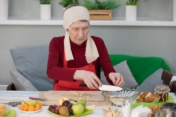 Elderly woman preparing fruit salad at home in the living room