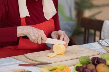 Elderly woman preparing fruit salad at home in the living room