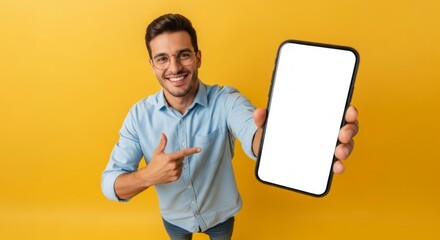 Smiling man pointing at a modern smartphone featuring a blank white screen, perfect for showcasing mobile apps, web designs, or custom digital content.