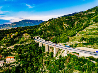 Aerial view of highway road with tunnel in mountains. Traffic on the road, cargo trucks logistic...