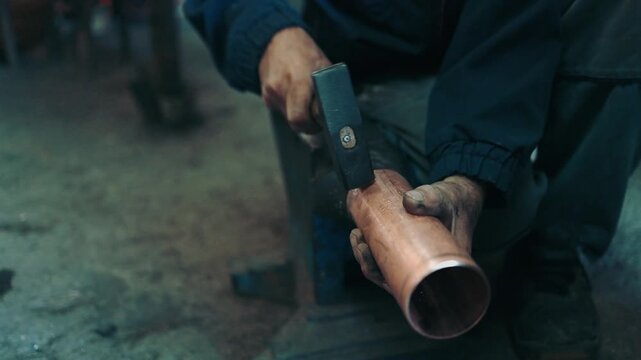 Traditional coppersmith workshop for copper brewing pots manufacturing. This handmade brewery kettles will be used for making traditional alcohol brandy drinks. Small traditional business concept.