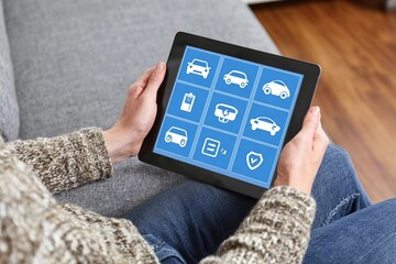 Exploring car services on a tablet while relaxing on a cozy couch