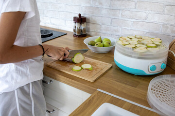 Slicing fresh pears for drying in a cozy kitchen during a sunny afternoon
