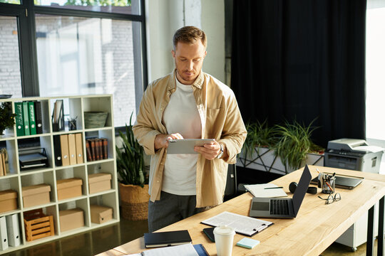 Young businessman engaged in productive work while using a tablet in a modern office environment