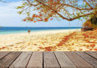 Fototapeta premium Wooden table top on the beach or sea.Party on the beach sunshine time concept.For montage product display or design key visual layout.View of copy space.