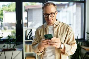 Young businessman engaged in important work while using smartphone in modern office space